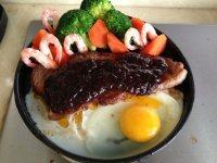 西冷牛排,将烧过的黑椒汁倒在牛排上,趁热切块食用
