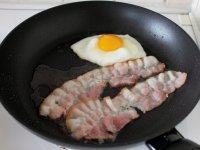 简易版培根煎蛋,接下来将两条培根平铺锅底