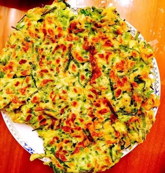 槐花鲜食,如果有神器鏊子就把搅拌好的槐花糊糊摊在鏊子上,一锅搞定,如果没有,就用平底锅两面煎成金黄色就可以出锅了。