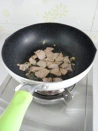 豉香里脊炒西兰花梗,锅子烧热，倒油，放入腌好的肉片，用筷子将肉片划散，炒至肉片变白。