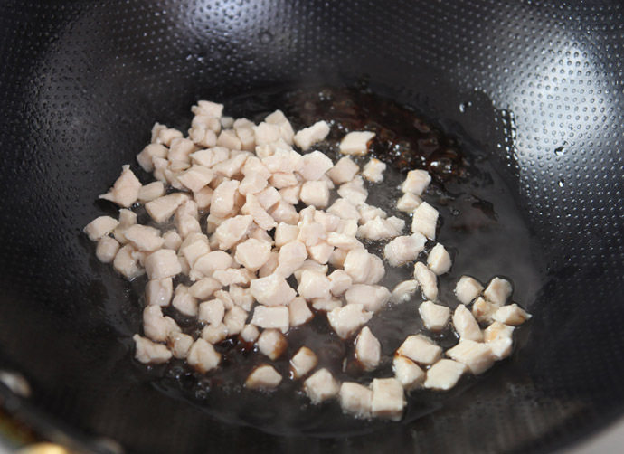 杏鲍菇酱爆鸡丁,倒入鸡丁,翻炒至鸡丁裹上酱色。