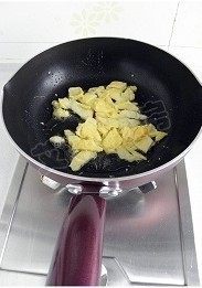 金枪鱼什锦炒饭,蛋液煎熟后用铲子铲盛小块