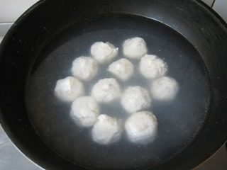 包心鱼丸,放入水中煮熟,捞出,盛入容器中。锅中倒入高汤,加盐和鸡精烧开,浇在鱼丸上,最后淋上香油和葱末即可。