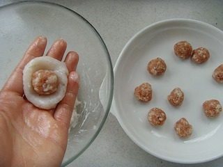 七星鱼丸,双手抹少许化猪油,取适量鱼泥包入馅料,搓圆。