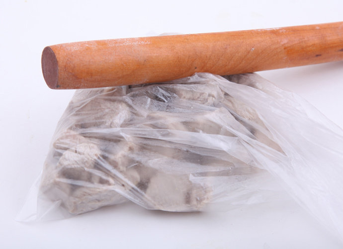 自制芝麻肉松,取出肉块沥干,放晾后装入保鲜袋,用擀面杖敲打肉块,使其松散成细条状。