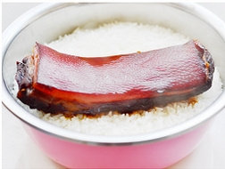 腊肉菌菇饭,取出，在米饭上放上一条腊肉，并加入1勺的<a style='color:red;display:inline-block;' href='/shicai/ 899'>花雕酒</a>去腻味，继续蒸，直到米饭和腊肉都蒸熟为止。