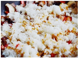 腊肉菌菇饭,加入打散的米饭，再次翻炒均匀。