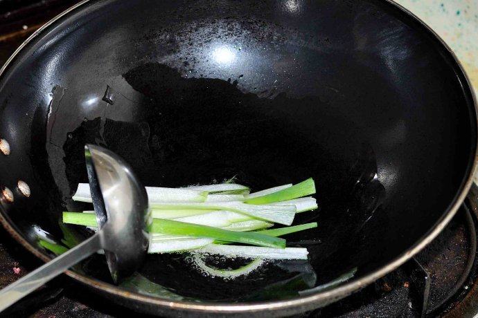 脆臊海参,锅内下少许猪油五成油温时下入葱段炸香后将葱段沥出