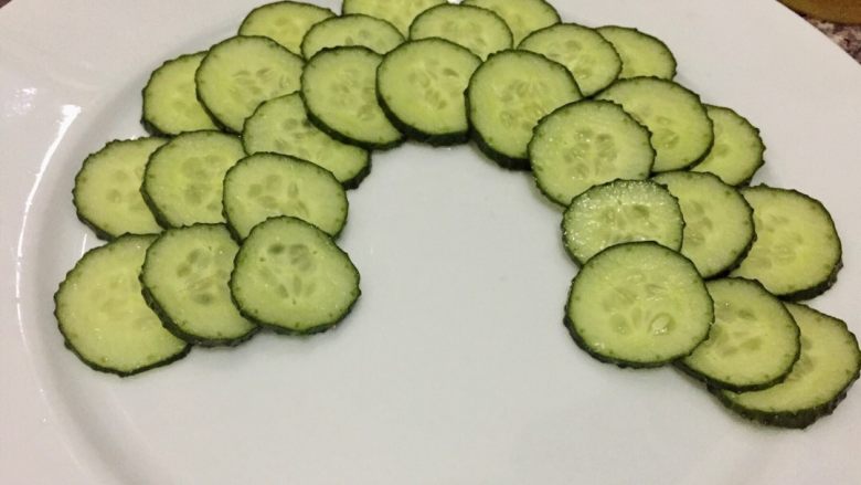 孔雀开屏~凉拌黄瓜片,黄瓜片一个挨着一个摆在盘子边缘,第二层压着第一层错开摆好,以此类推