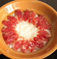 腊肠煲仔饭,锅里的水干时，放入切好片的<a style='color:red;display:inline-block;' href='/shicai/ 4536'>腊肠</a>，然后继续盖上盖子，保持小火，焖至<a style='color:red;display:inline-block;' href='/shicai/ 4536'>腊肠</a>香味散发出来