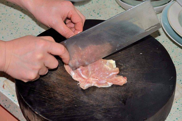 酱爆鸡丁,去骨的鸡腿肉用后部分刀尖依次排一遍后切成鸡丁，排目的是斩断鸡腿上的经络。