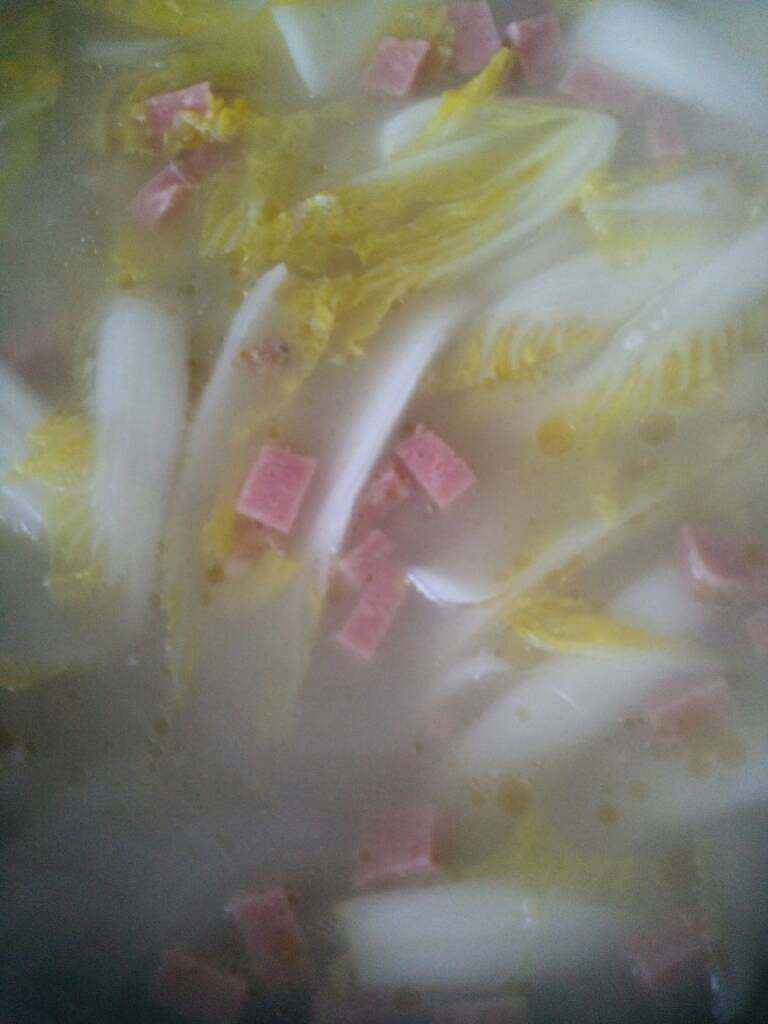 娃娃汤,出锅先把菜和粉丝捞出铺在碗底,再把皮蛋丁和火腿丁当在上边,倒入浓汤