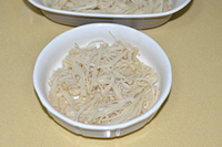 酸汤肥牛 ,金针菇放入开水锅中烫熟,滤干水份铺于碗中。