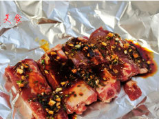 酥香鲜嫩烤排骨 ,将肋排放在用锡纸上,浇上秘汁,再把四周上卷,包成一个小包,防止汁流出来