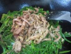 青椒榨菜肉丝,继续翻炒到青椒丝9成熟,倒入肉丝