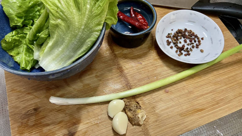 椒盐豆腐,生菜掰成一片片,清洗备用,干辣椒清水浸泡,小葱择好洗净,蒜剥皮,姜搓洗干净