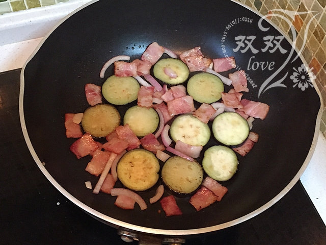 茄子培根蛋饼,茄子煎软,培根变色,洋葱出香味,将茄子片和培根码在锅底