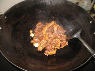 子姜焖鸭,起油锅,爆香蒜头,下鸭子煸炒至皮有点焦黄。