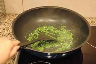 香煎菜脯蛋,平底锅油热后,将韭菜花倒入稍加煸炒;