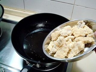 酥糊里脊,把腌好的肉片逐一沾好酥炸糊,然后下入四成热的油锅中进行炸制。