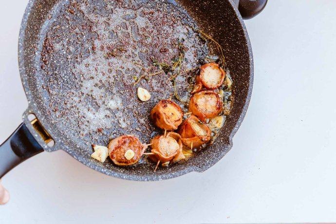 培根扇贝卷,正反面煎好后，别忘记侧面也要煎，放入蒜片与<a style='color:red;display:inline-block;' href='/shicai/ 887'>黄油</a>