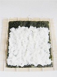 紫菜包饭,铺好的米饭要用手压平,米饭不要铺满,要留一小条紫菜不铺米饭