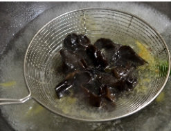 油淋腰花,锅里烧大量水,下入姜片、香葱结,另取10粒花椒放入,烧开后放木耳汆熟捞出。