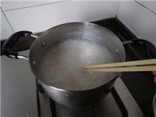 生滚鱼片粥,下入鱼片,并用筷子轻轻划散,压入粥中;