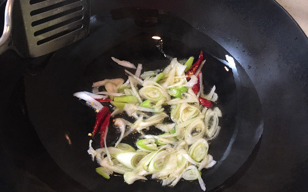 西芹炒豆干,热锅凉油,下干辣椒炒一下,再下入大葱炒出香味