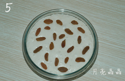 葡萄干发糕,放在温暖处发酵至原来体积的两倍大,在发酵好的面糊表面撒上葡萄干.