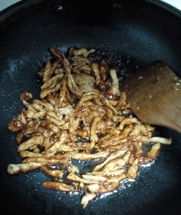 京酱肉丝,加入肉丝翻炒,使肉丝都均匀的沾上酱即可取出装盘,用豆腐片卷着吃