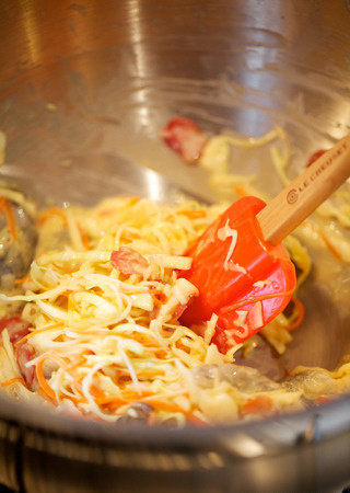 大阪烧,入卷心菜丝、胡萝卜丝、<a style='color:red;display:inline-block;' href='/shicai/ 4536'>腊肠</a>薄片、虾肉,搅拌至均匀裹住面糊,盐调味