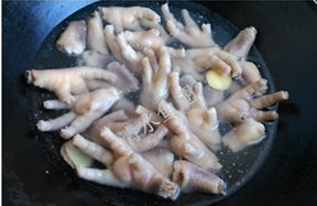 五香脱骨虎皮凤爪 ,将炸过的鸡爪倒入凉水，放入冰箱，直到将鸡爪泡到膨胀。