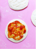 鲜虾迷你披萨,扎孔，抹上番茄酱