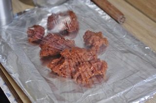 蜜汁猪肉脯,锡纸在烤盘中摁出印。拿出来刷上一层食用油,350克肉馅倒出来盖上一层保鲜膜用手拍均匀