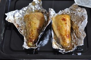 烤酿鸡腿,打开锡纸刷一层油撒芝麻,再烤十分钟即可
