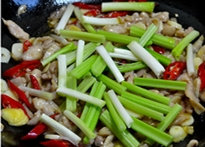 香香鸡,开中火,放入芹菜和葱白段,翻炒断生。