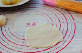 雪媚娘,取约30克面团,蘸少许炒熟的糯米粉擀成薄面皮。