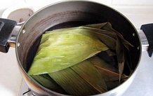 粽香五花肉,粽叶用清水略泡一下；锅内烧清水，水开后把粽叶烫一烫取出待用