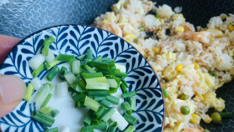 玉米虾仁蛋炒饭,撒入葱花炒均匀即可食用