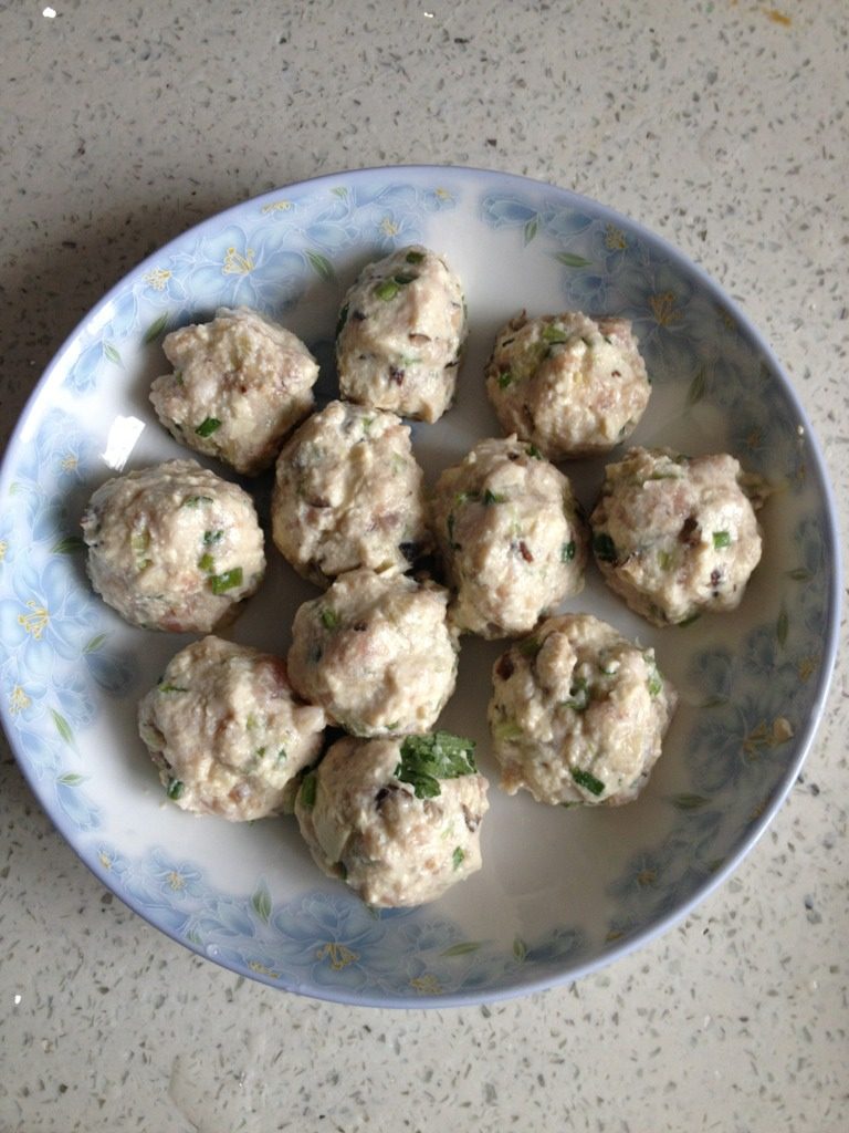 烧汁豆腐肉丸子,戴上一次性手套把馅料搓圆放在碟子里,放入煮沸水的蒸锅蒸10分钟