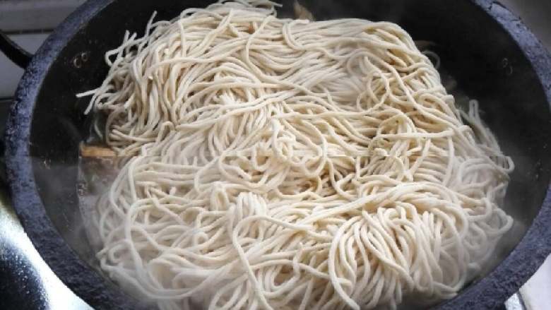 豆角焖面,放入面条，要平铺在上面。过五分钟把面条翻一个面。