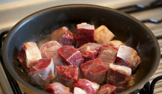 炖牛肉烤土豆和胡萝卜,平底锅内入黄油，中高火煎牛肉块各面