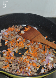 孜然澳洲羊肉炒饭,倒入切好的洋葱和胡萝卜丁，炒大约一分钟，洋葱出香味