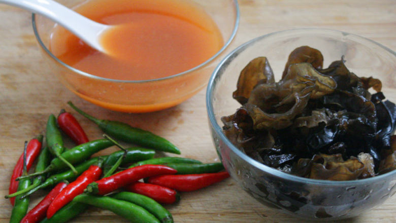 酸辣双椒黑木耳,把<a style='color:red;display:inline-block;' href='/shicai/ 136'>黑木耳</a>在温水里泡发开，然后清洗干净备用；锅里水烧开后，放入<a style='color:red;display:inline-block;' href='/shicai/ 136'>黑木耳</a>，煮10秒后捞起，放入凉开水中，然后沥干水分备用