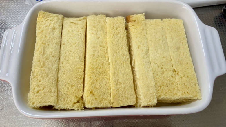 法式牛奶烤吐司,吐司三片切去吐司边,根据烤盘宽度切长条,摆入烤盘