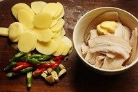 回锅肉炒土豆片,五花肉片水开煮一下控水捞出备用。土豆去皮切片,辣椒切段,蒜拍碎。