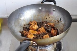 梅干菜蒸排骨,倒入老抽,生抽,白糖,盐,中火翻炒排骨上色。倒入泡好的梅干菜,关火拌匀