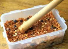 苕丝糖,倒入容器中,我用的是塑料饭盒可以不用抹油,如果是其他,可能需要往容器内壁上涂上一层油以免不好脱模。用擀面棒轻轻的敲压表面,不要太用紧,轻轻压一下再整平就好了