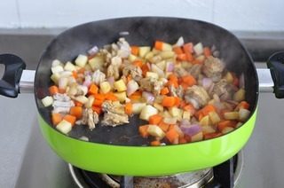 简易版羊肉手抓饭,锅里放两茶匙食用油,小火炒香洋葱,把土豆胡萝卜羊肉一起下锅炒匀,加盐,生抽,孜然粉拌匀
